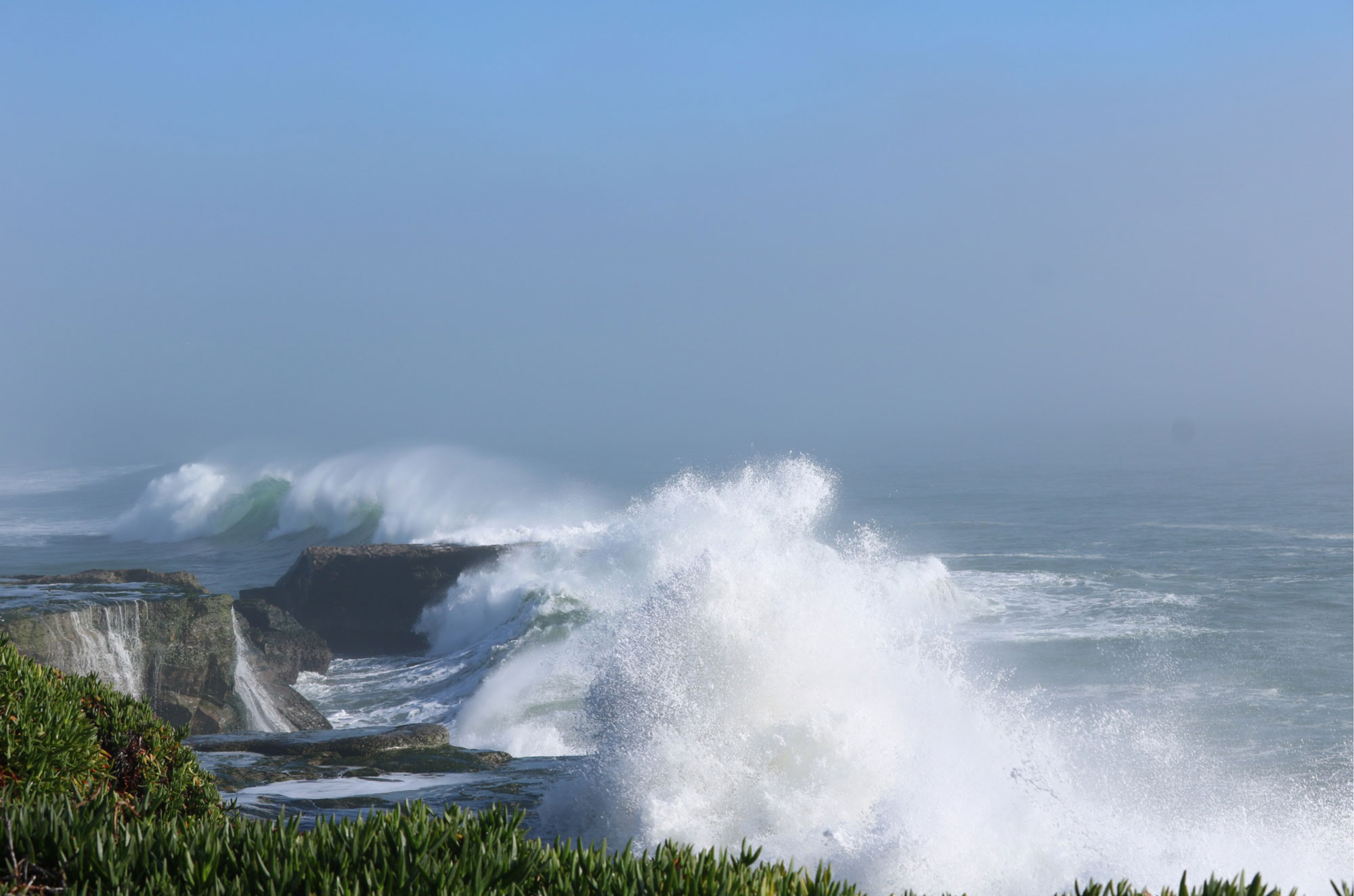 Waves crashing on a cliff along West Cliff in Santa Cruz, CA, USA.